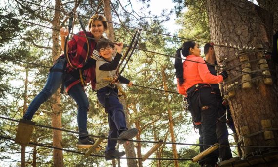 A family enjoys a thrilling day on a ropes course in Cercedilla, Spain.