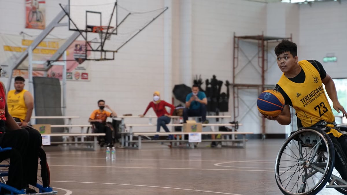 Dynamic wheelchair basketball game showcasing skill and determination indoors.